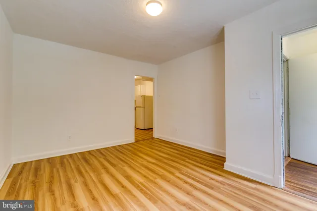 a view of a room with wooden floor and white walls