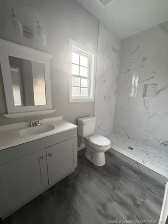 a bathroom with a double vanity sink toilet and shower
