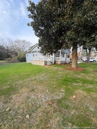 a front view of a house with a yard and trees