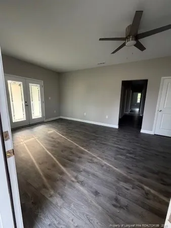 a view of a livingroom with wooden floor and a ceiling fan