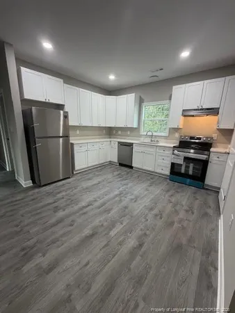 a kitchen with a refrigerator and a stove top oven