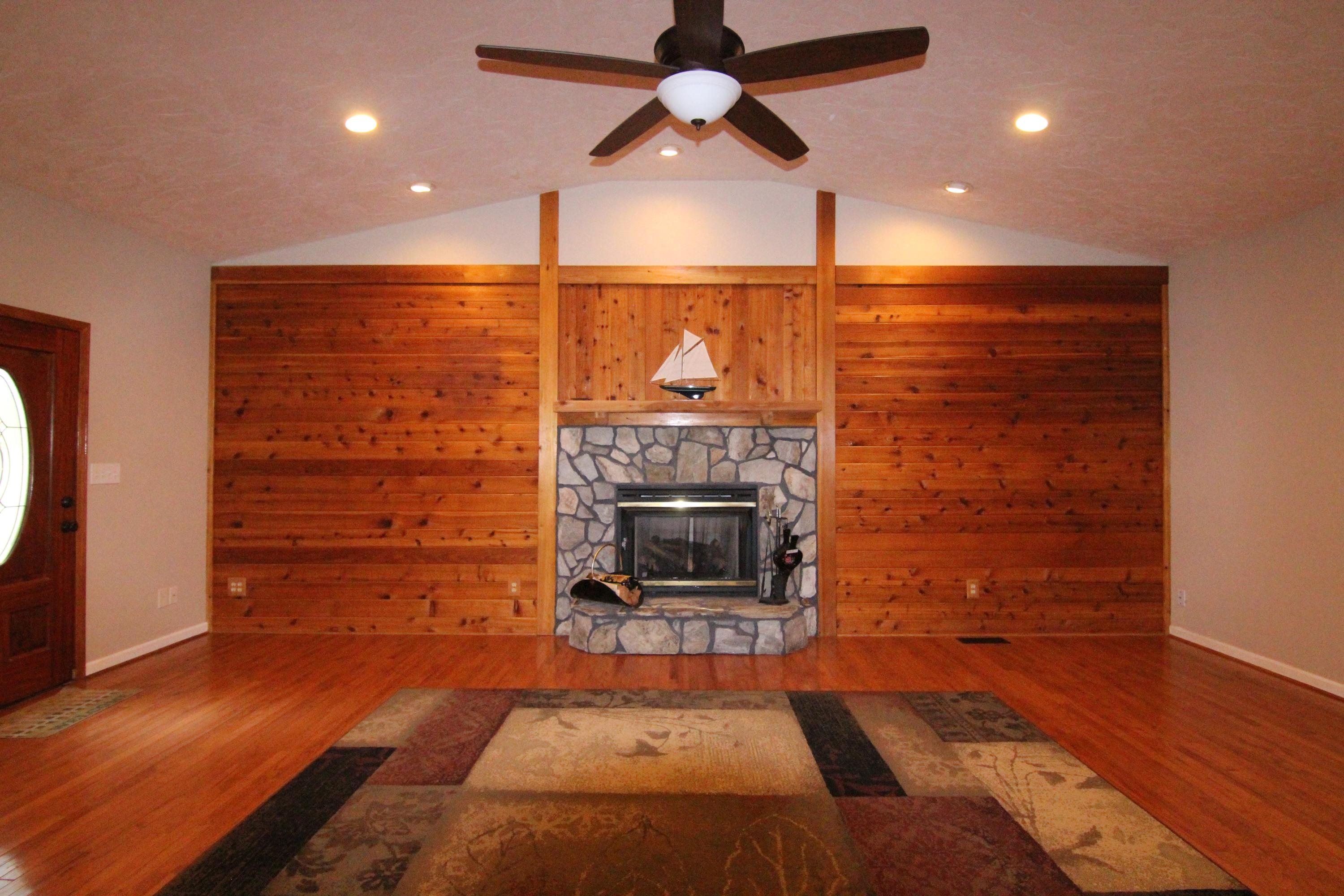 6773 Goodview Road Goodview, VA 24095 - Photo 14 of 43 wooden floor in an empty room with a fireplace