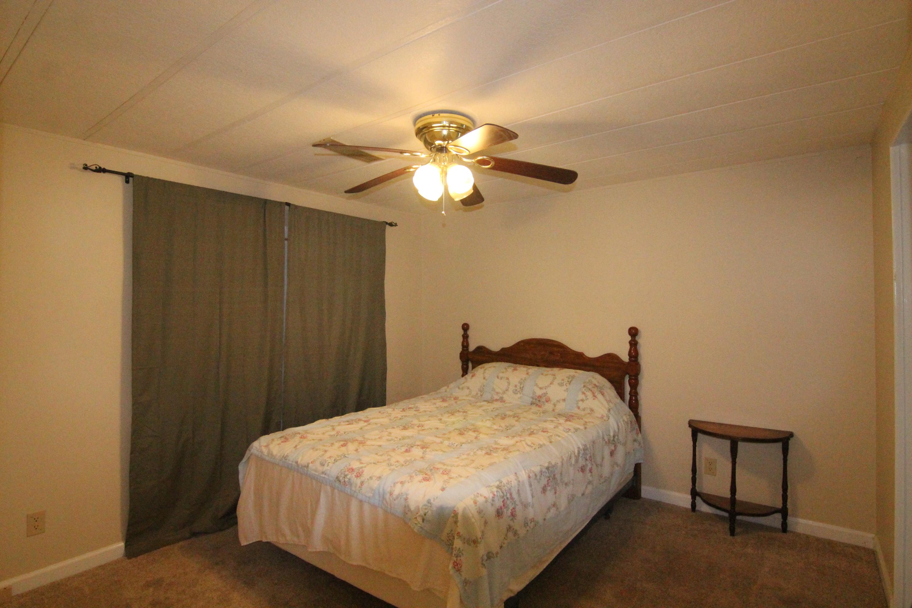 6773 Goodview Road Goodview, VA 24095 - Photo 22 of 43 a bedroom with a bed and a chandelier