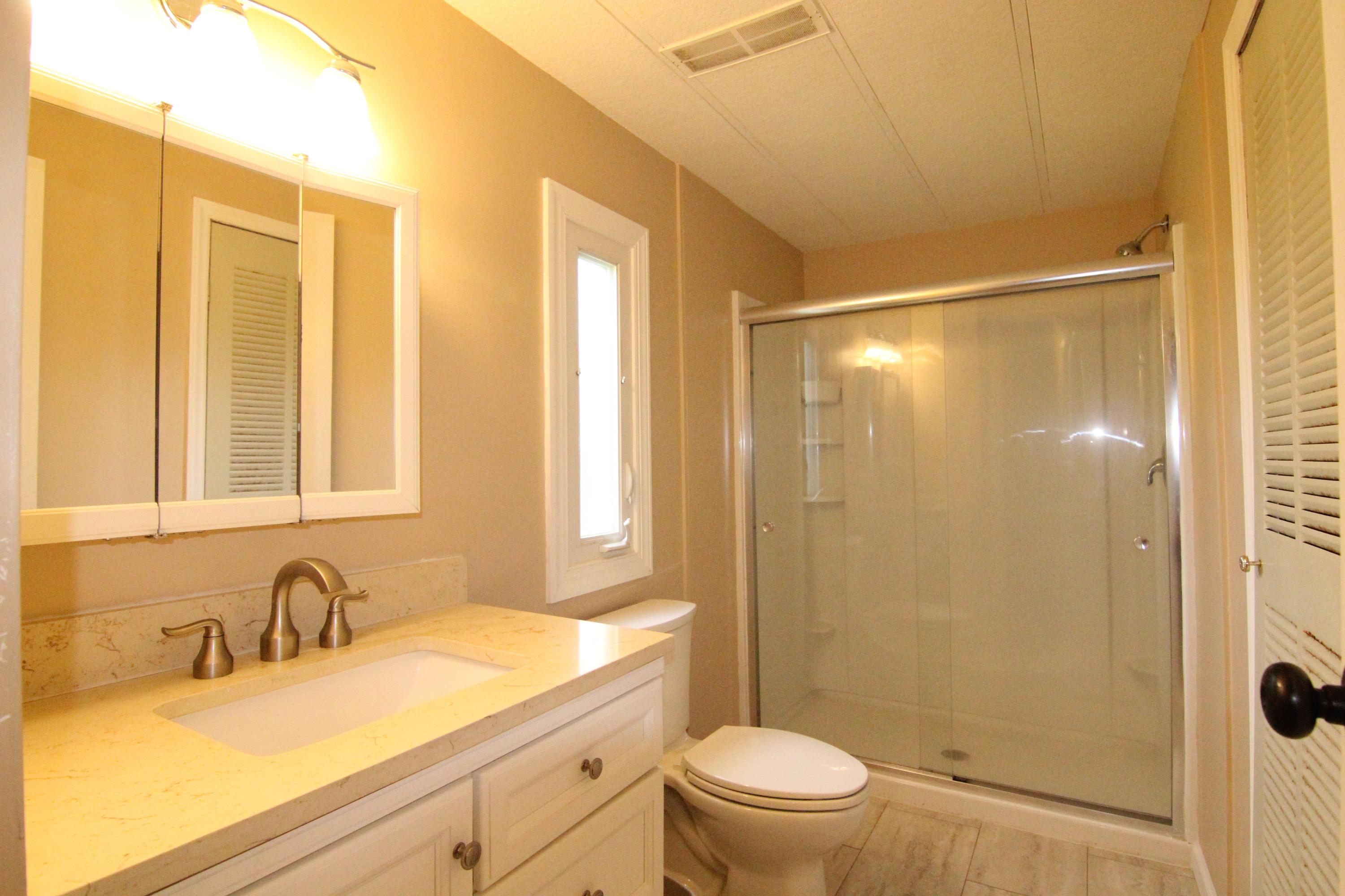 6773 Goodview Road Goodview, VA 24095 - Photo 23 of 43 a bathroom with a granite countertop sink toilet and shower