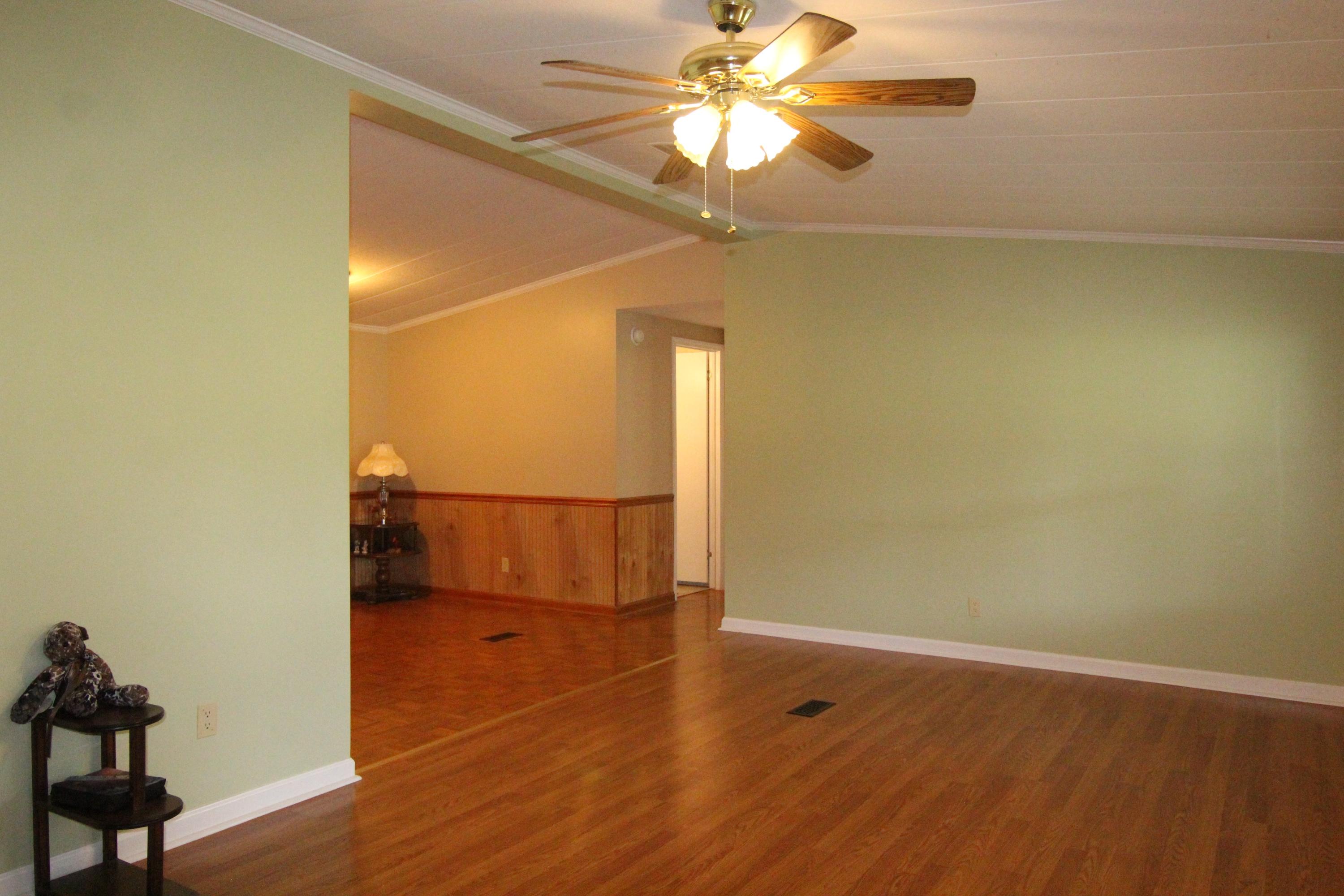 6773 Goodview Road Goodview, VA 24095 - Photo 5 of 43 an empty room with wooden floor fan and windows
