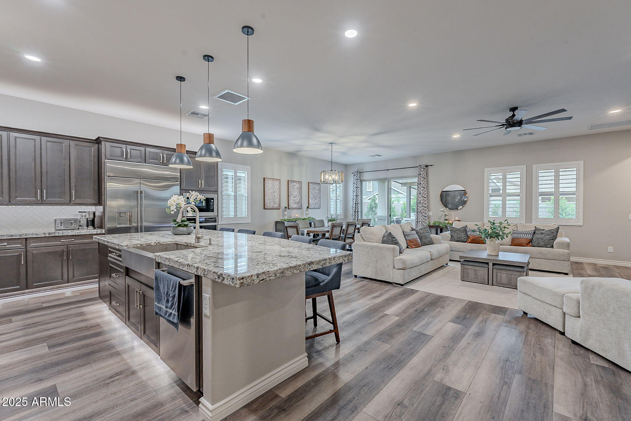 22900 East Reins Road Queen Creek, AZ 85142 - Photo 15 of 74 a large kitchen with kitchen island a stove a sink a dining table and chairs