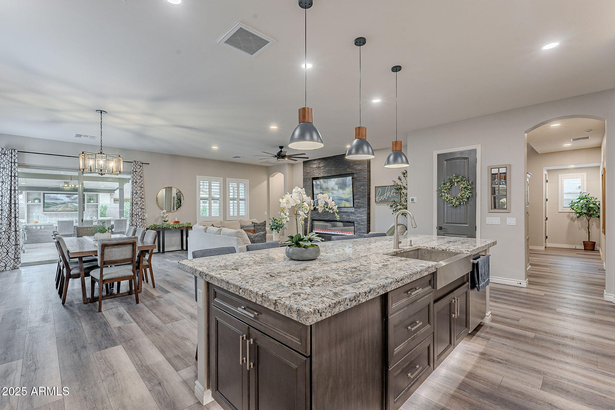 22900 East Reins Road Queen Creek, AZ 85142 - Photo 16 of 74 a kitchen with granite countertop kitchen island stainless steel appliances sink dining table and chairs