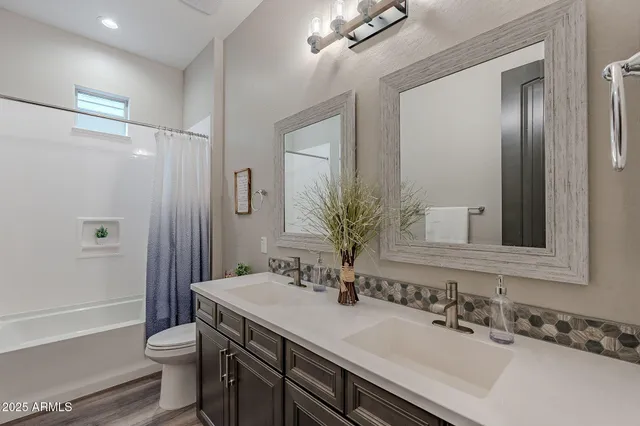 a bathroom with a double vanity sink mirror and toilet