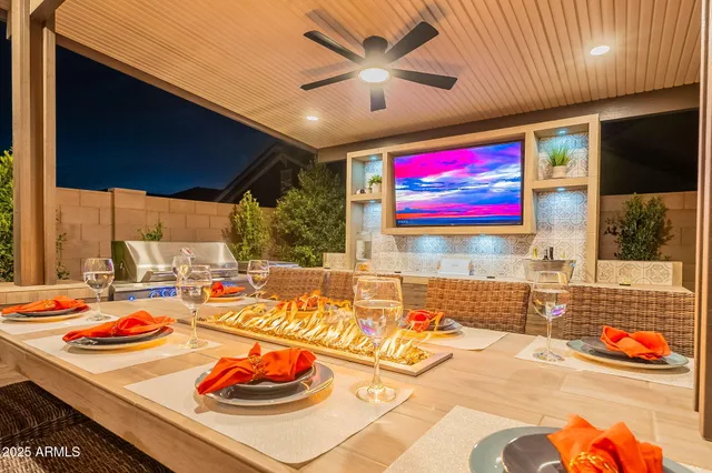 a living room with table chairs and a flat screen tv