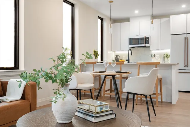 a living room with furniture kitchen view and a potted plant