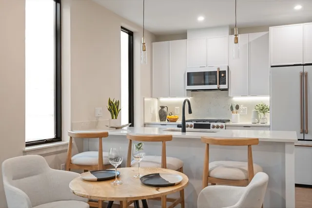 a kitchen with stainless steel appliances a dining table and chairs
