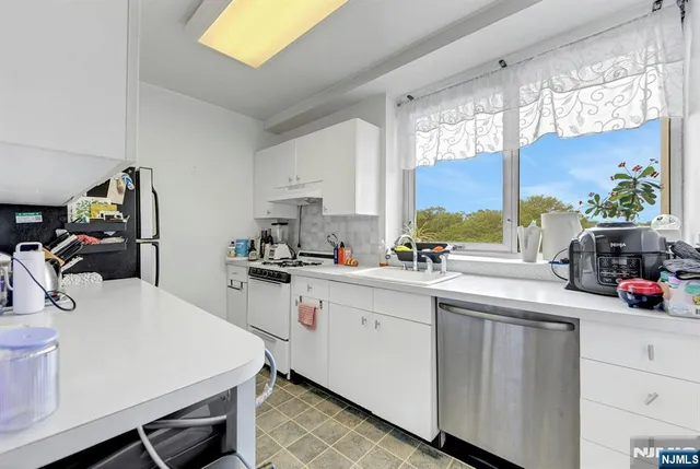 a kitchen with a sink a stove and cabinets