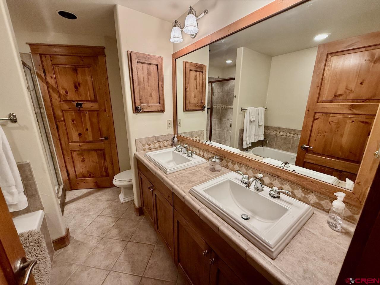 9 Hunter Hill Road, Unit 104 Crested Butte, CO 81225 - Photo 15 of 38 a spacious bathroom with a sink a mirror and a bathtub