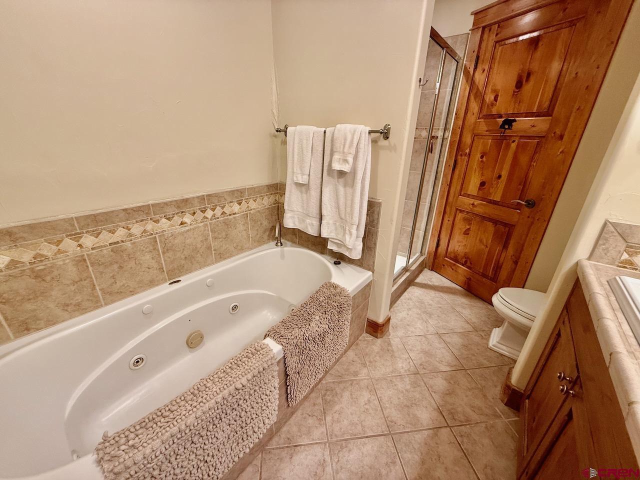 9 Hunter Hill Road, Unit 104 Crested Butte, CO 81225 - Photo 16 of 38 a bathroom with a tub a sink and a large window