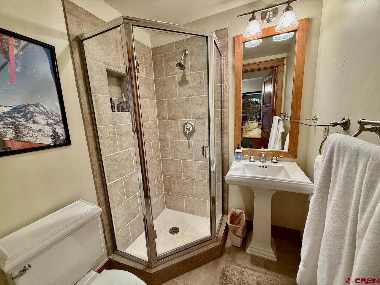 9 Hunter Hill Road, Unit 104 Crested Butte, CO 81225 - Photo 20 of 38 a bathroom with a shower a mirror and a sink