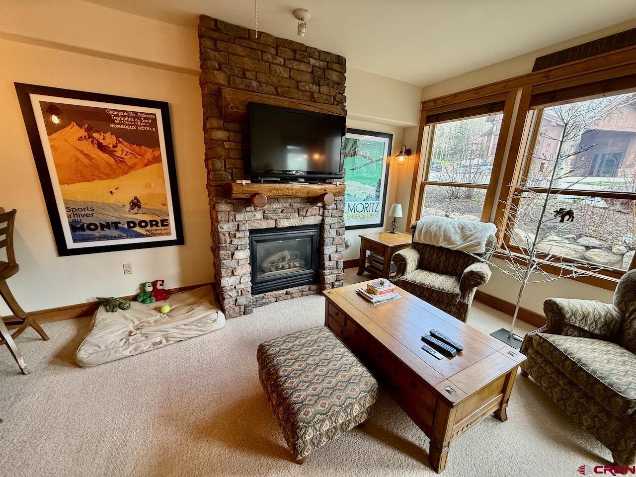9 Hunter Hill Road, Unit 104 Crested Butte, CO 81225 - Photo 2 of 38 a living room with furniture a flat screen tv and a fireplace