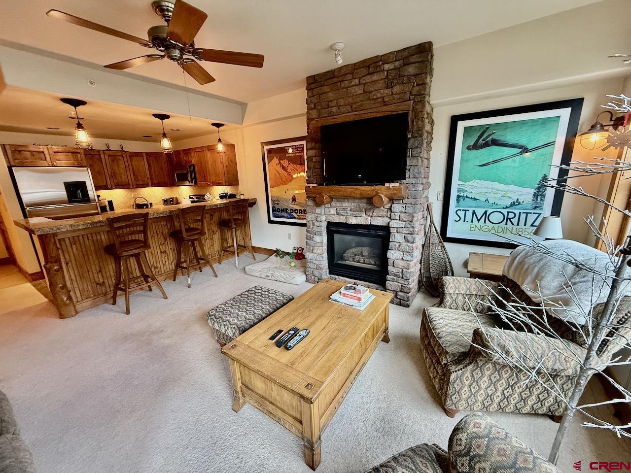 9 Hunter Hill Road, Unit 104 Crested Butte, CO 81225 - Photo 3 of 38 a living room with furniture a flat screen tv and a fireplace