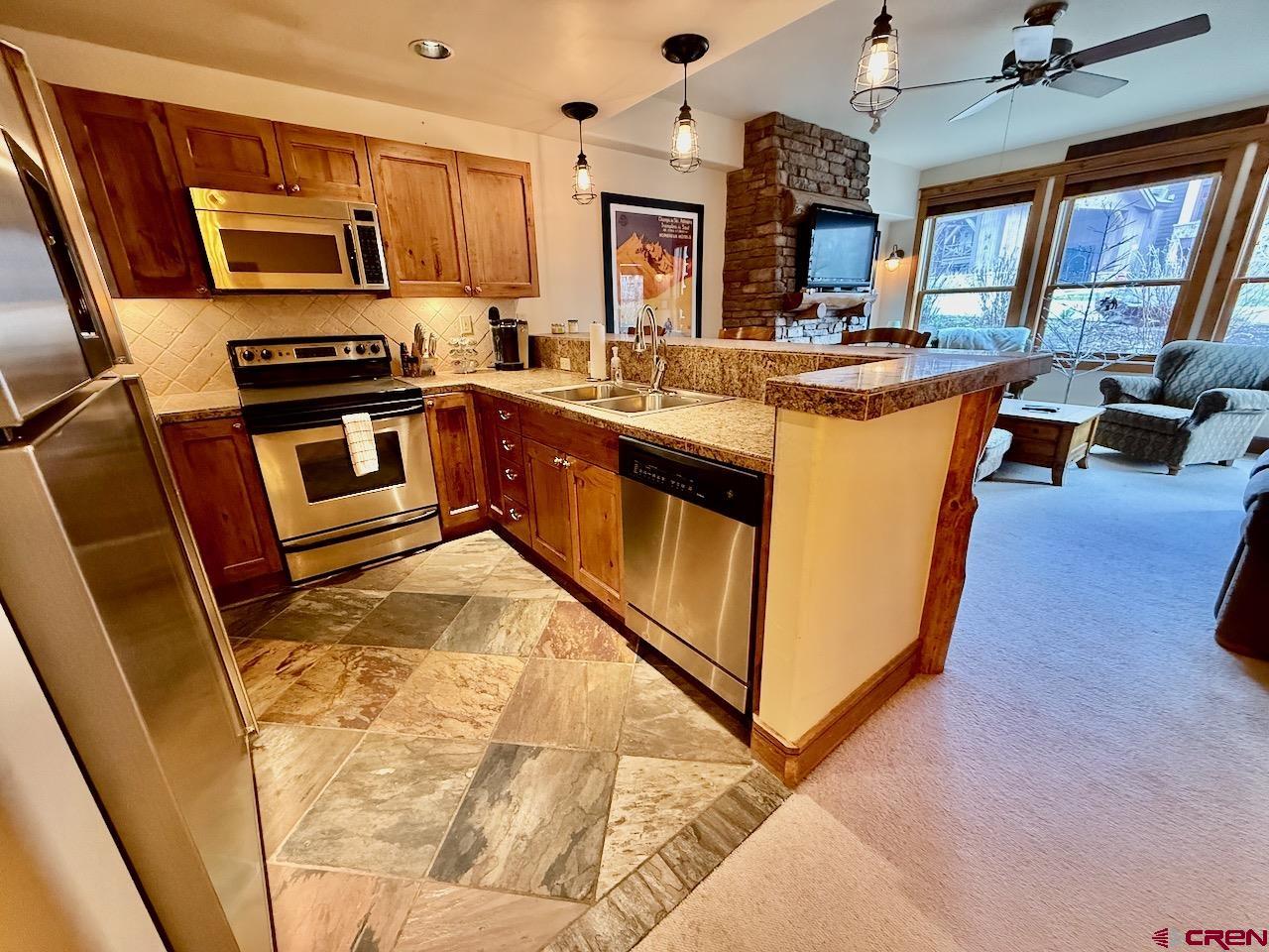 9 Hunter Hill Road, Unit 104 Crested Butte, CO 81225 - Photo 10 of 38 a kitchen with stainless steel appliances granite countertop a stove a sink and a microwave