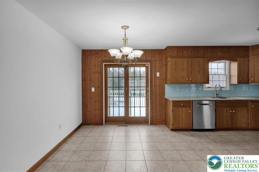 282 Ernst Road Mohrsville, PA 19541 - Photo 11 of 50 a large kitchen with granite countertop a stove a sink and a chandelier