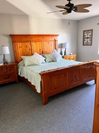 a bed room with a bed and a ceiling fan