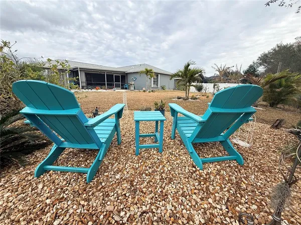 a view of a chairs and table in backyard