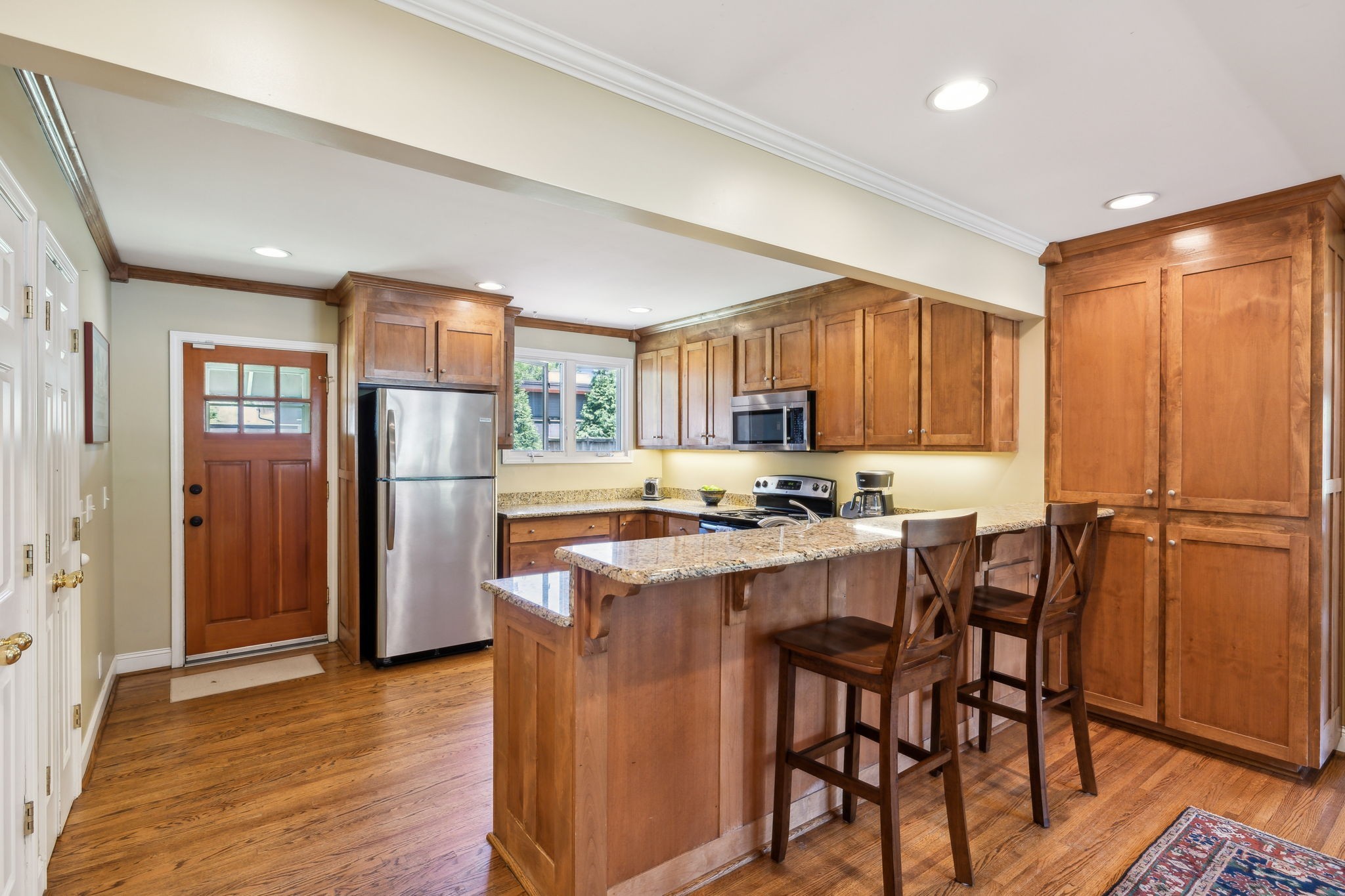 4202 Murphy Road Nashville, TN 37209 - Photo 6 of 34 a kitchen with stainless steel appliances a refrigerator a stove a sink a dining table and chairs with wooden floor