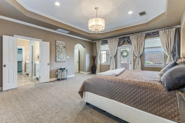 a spacious bedroom with a large bed and a large window