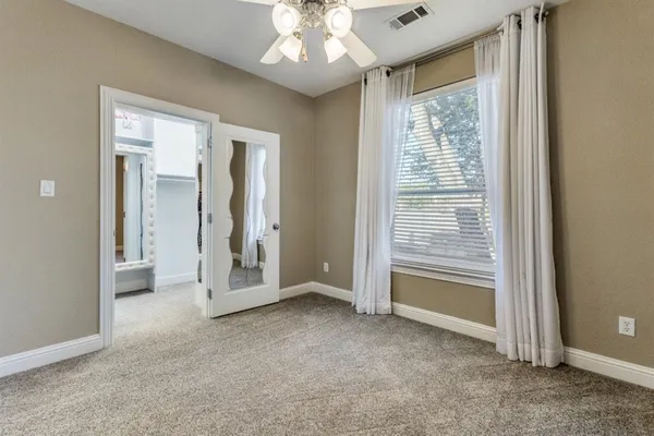 an empty room with fan and entrance