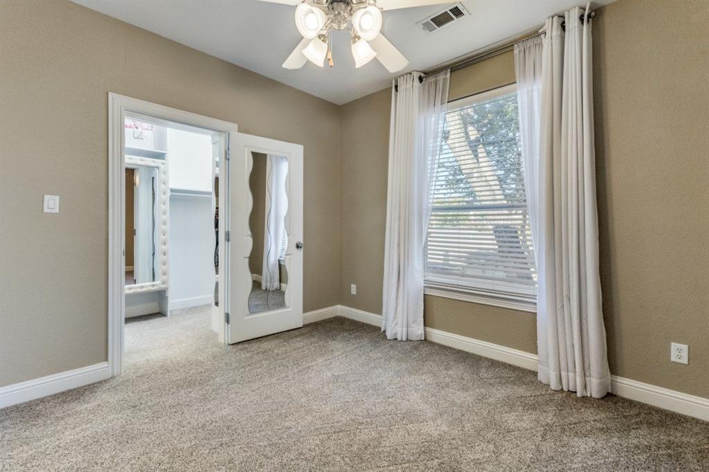 4931 Homer Street Dallas, TX 75206 - Photo 19 of 29 an empty room with chandelier fan and windows