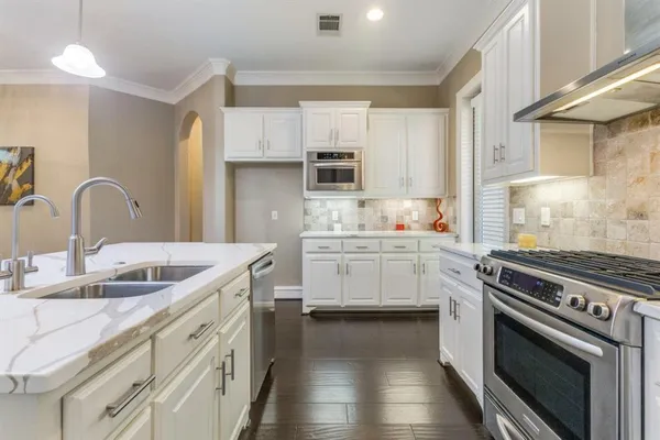 a kitchen with a sink stove and cabinets