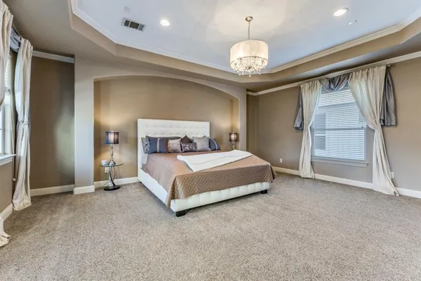 a bedroom with a bed and a chandelier