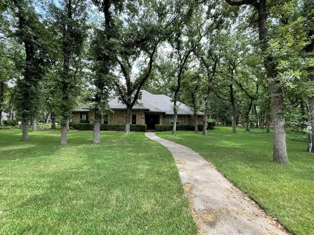 a view of a yard with wooden deck and trees
