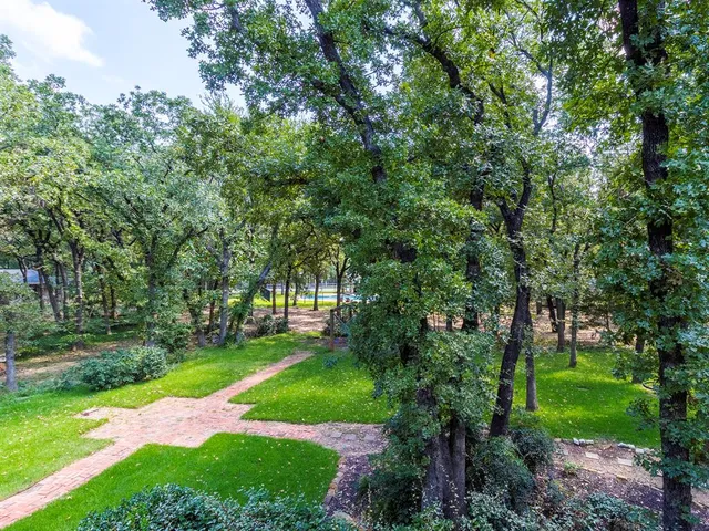 a view of a swimming pool with lawn chairs under an umbrella