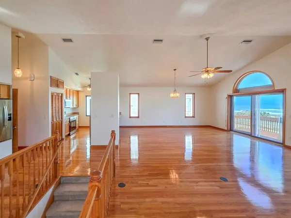 a view of a room with wooden floor fire place and furniture