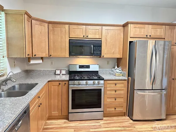 a kitchen with granite countertop a refrigerator stove and microwave