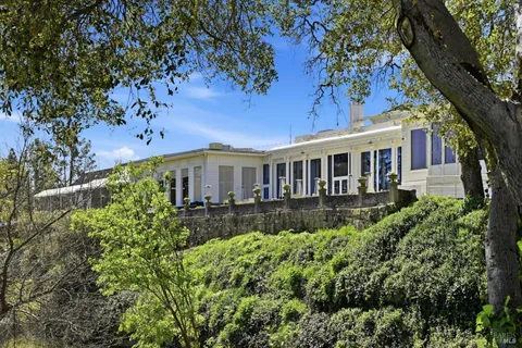 a view of a chairs and table in patio with a yard