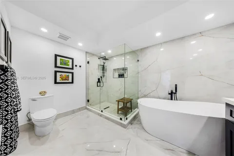 a bathroom with a sink a toilet and a large mirror