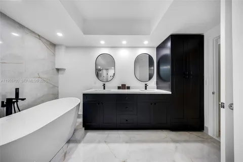 a bathroom with a bathtub sink and mirror