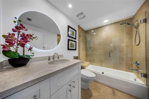 a bathroom with a granite countertop sink a toilet and bathtub