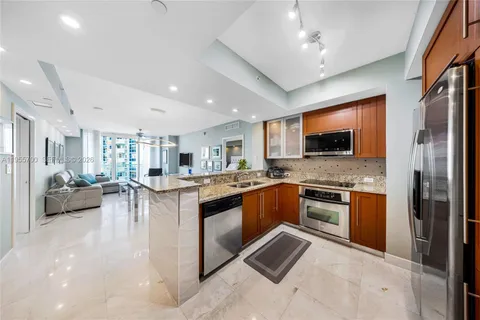 a large kitchen with stainless steel appliances granite countertop a stove and a sink