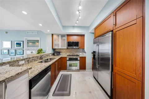 a large kitchen with a stove top oven a sink and stainless steel appliances