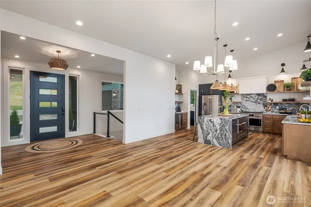 a kitchen with stainless steel appliances granite countertop a sink a stove and a refrigerator