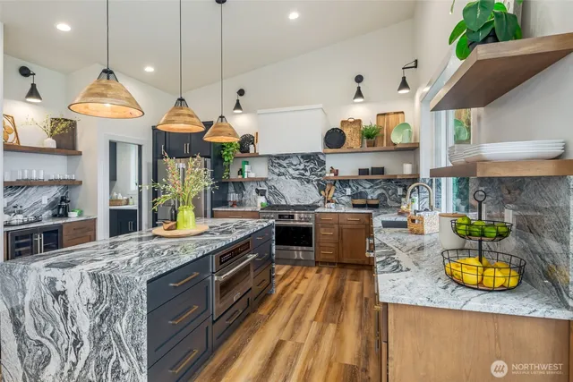 a outdoor kitchen with granite countertop a sink and a large window
