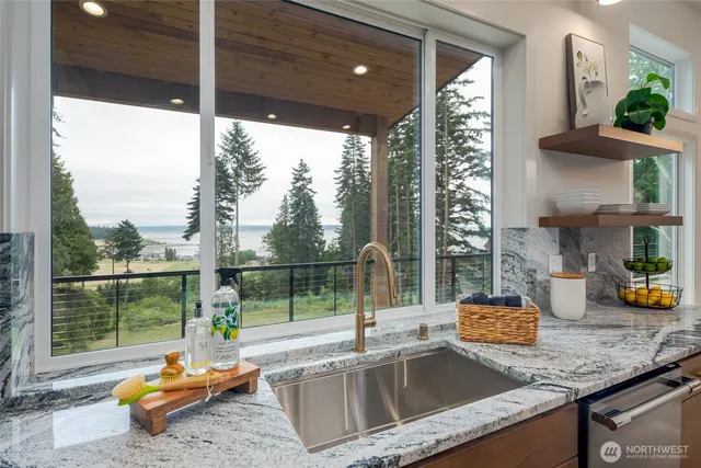 a kitchen with stainless steel appliances granite countertop a sink a stove and a refrigerator