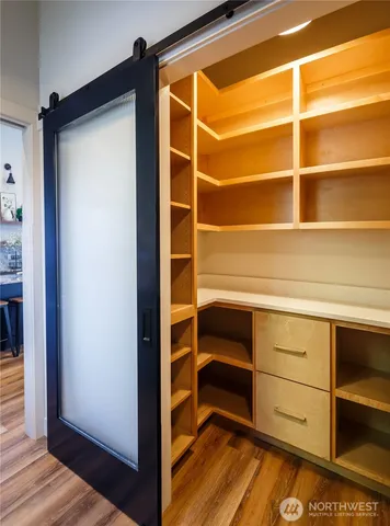a kitchen with kitchen island granite countertop wooden cabinets and a chandelier