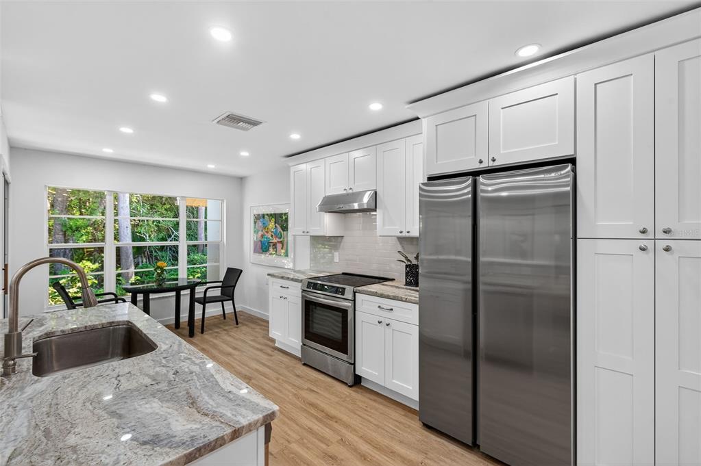 4916 Troon Lane New Port Richey, FL 34655 - Photo 25 of 53 a kitchen with kitchen island a large counter top space a sink stainless steel appliances and cabinets