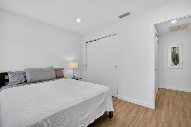 a bedroom with a bed and wooden floor