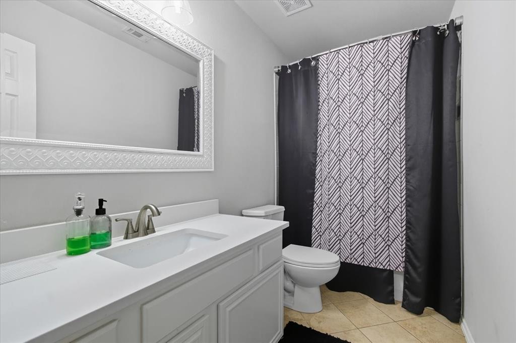 409 Springtree Road Lake Dallas, TX 75065 - Photo 35 of 40 Single vanity with a white countertop and integrated sink, brushed nickel faucet, and decorative framed mirror