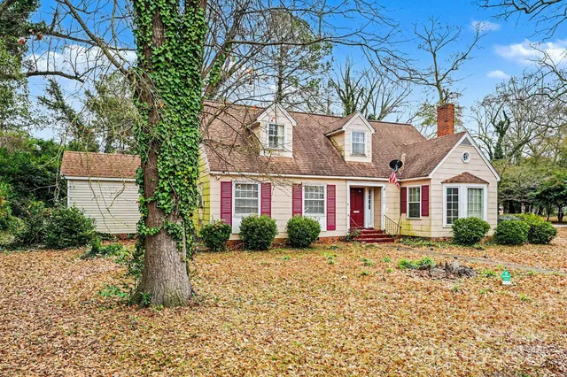 a view of a white house with a yard and plants