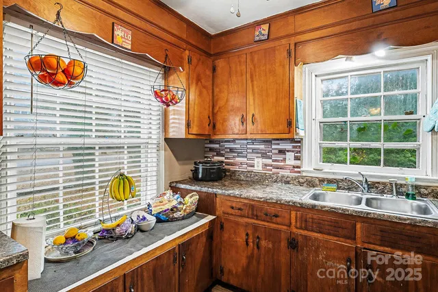 a kitchen with stainless steel appliances a sink window and cabinets